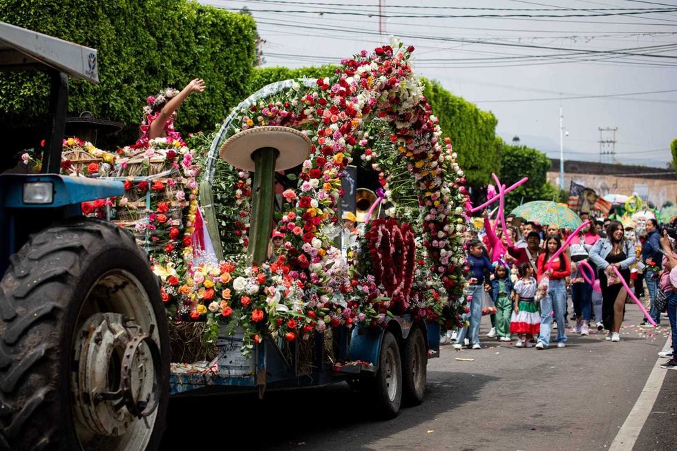 Un carro aleg\u00f3rico cubierto de flores avanza entre familias reunidas en el centro de San Juan del R\u00edo.