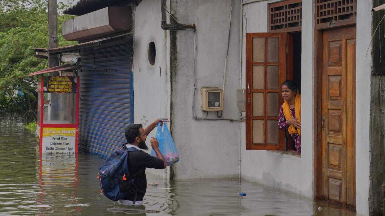 Un hombre brinda ayuda a una mujer atrapada en una casa en una zona inundada de Colombo, Sri Lanka, el sábado 29 de noviembre de 2025. AP.