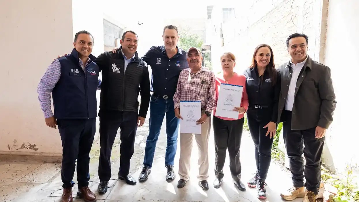 Una familia muestra su título de propiedad ante el gobernador Mauricio Kuri González en San Juan del Río