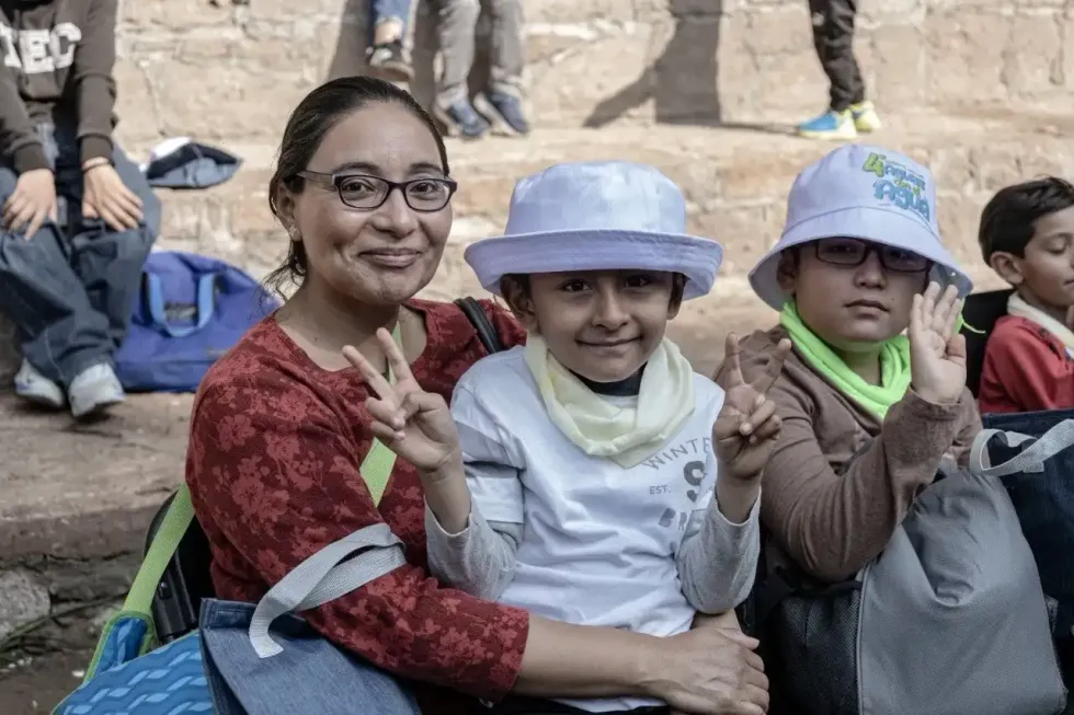 Una mujer acompa\u00f1a a dos ni\u00f1os participantes del curso de verano Aguas con el Agua.