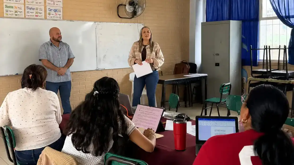 Una mujer y un hombre se dirigen a un grupo de docentes durante el taller intensivo de la USEBEQ en un aula