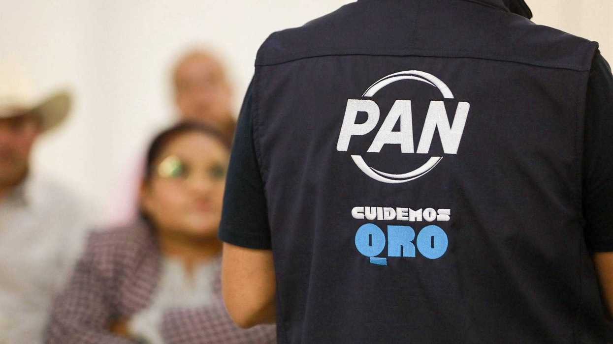 Una persona de espaldas viste un chaleco del PAN con la leyenda “Cuidemos QRO” frente a asistentes sentados, en la nota sobre la veda del PAN y las entrevistas de alcaldes en Querétaro.