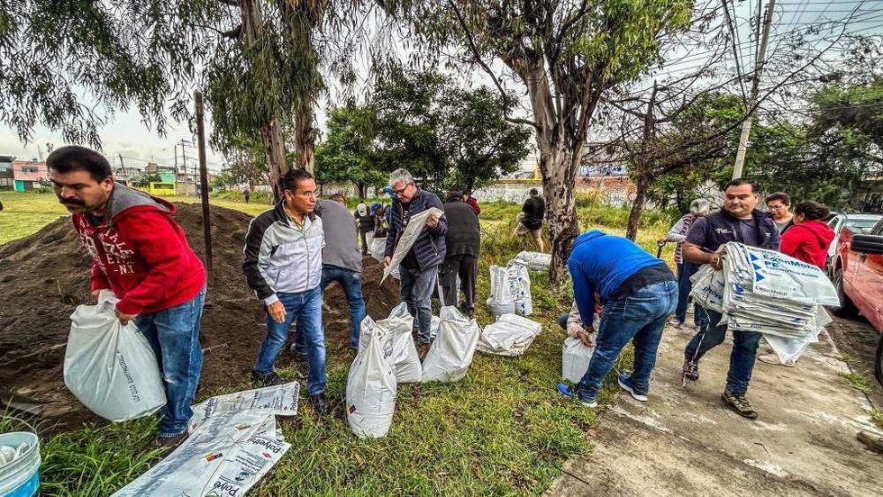 Vecinos de Manantiales llenan costales de arena en jornada preventiva.
