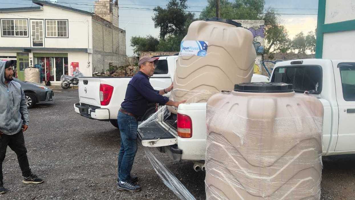Vecinos reciben tinacos a bajo costo en la plaza de una comunidad rural de San Juan del Río durante la entrega municipal, agosto de 2026.