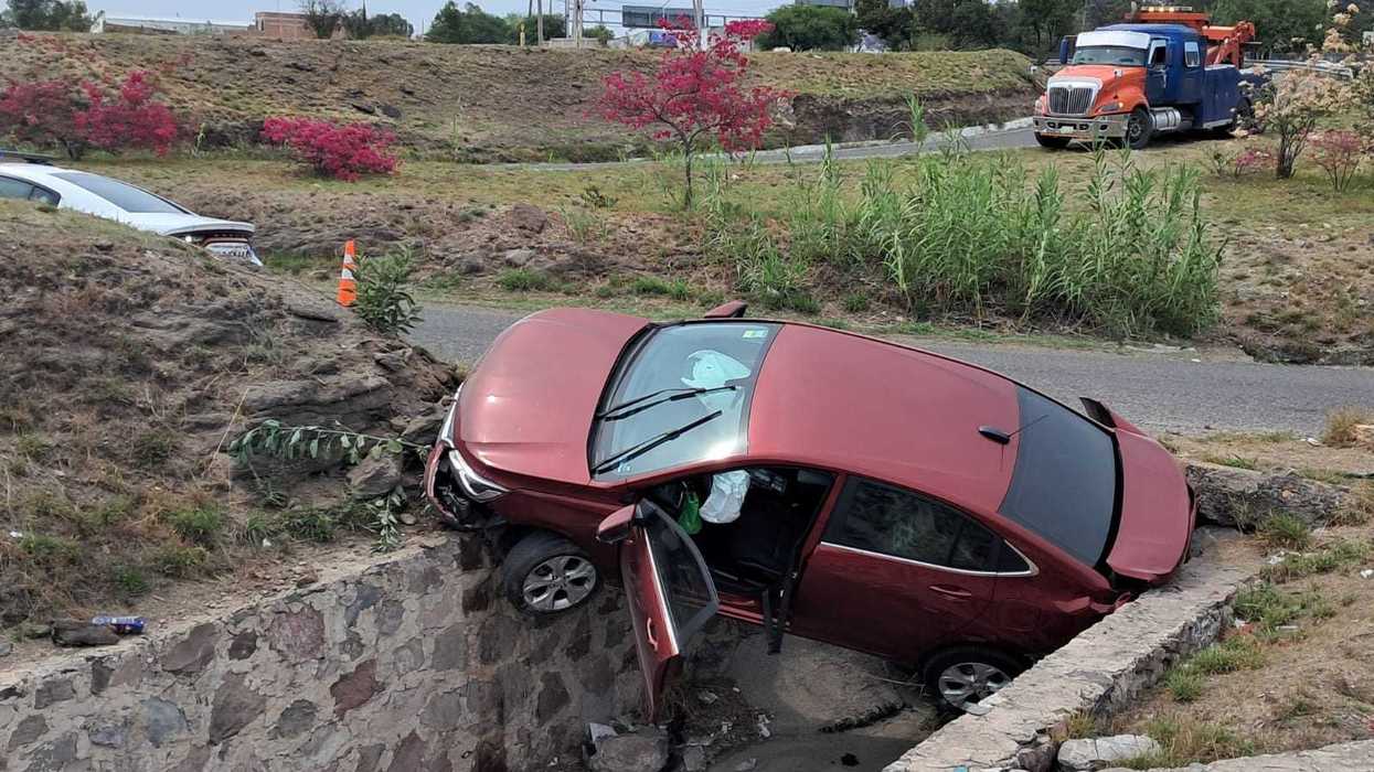 Vehículo Chevrolet accidentado en el interior de drenaje pluvial del distribuidor Paseo Central autopista México-Querétaro en San Juan del Río