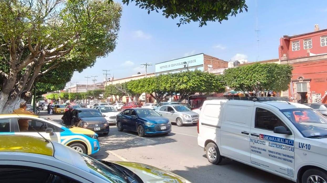 Vehículos circulan por una calle de San Juan del Río, donde habrá cierres viales por la Cabalgata de Día de Muertos