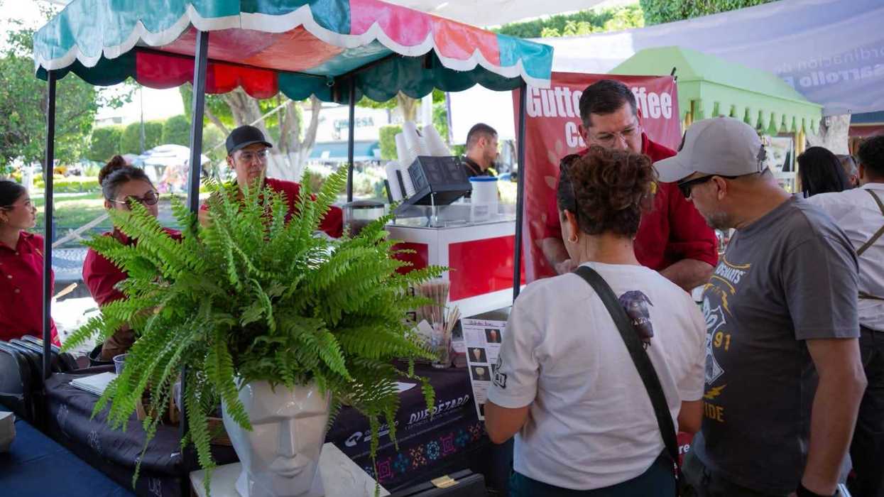 Visitantes consultan el menú en un puesto de café del Festival del Café en San Juan del Río.