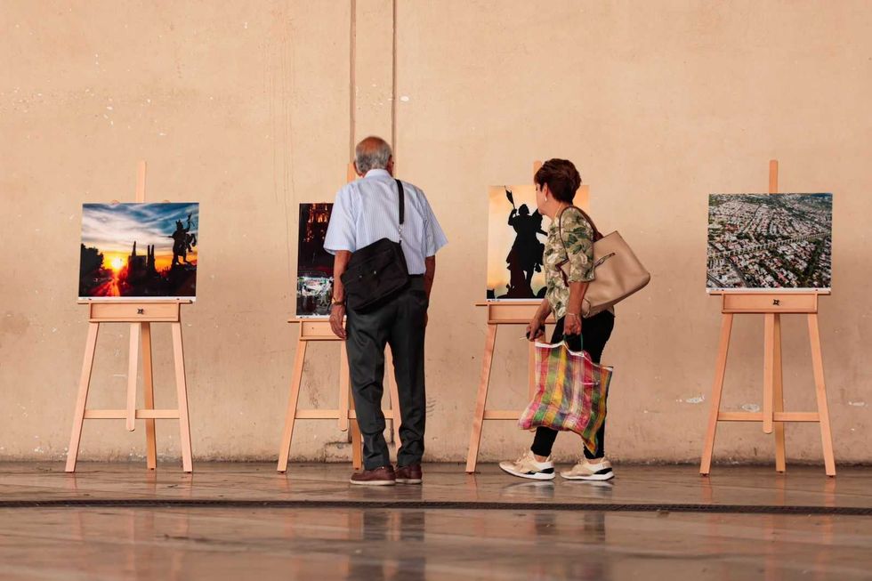 Visitantes observan fotograf\u00edas exhibidas en los pasillos de un mercado municipal de Quer\u00e9taro durante la muestra itinerante.