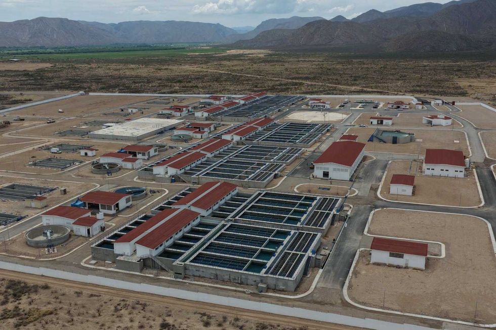 Vista a\u00e9rea de m\u00f3dulos de tratamiento y caja de rebose con letrero de Conagua en la planta potabilizadora Agua Saludable para La Laguna