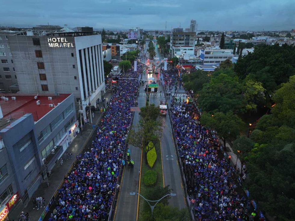 Vista a\u00e9rea de miles de corredores del Quer\u00e9taro Marat\u00f3n 2026 en una avenida de la ciudad con pavimento mojado