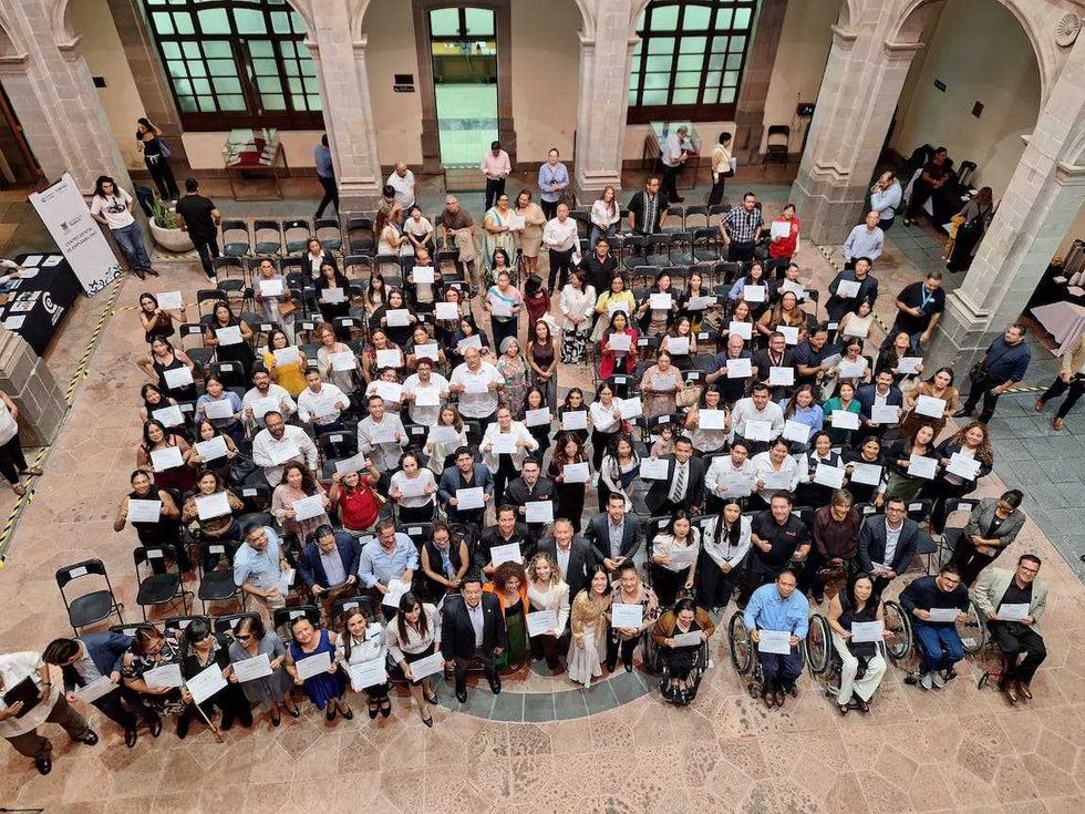 Vista a\u00e9rea desde el balc\u00f3n del recinto con los 315 egresados del Diplomado Virtual en Inclusi\u00f3n y Diversidad Laboral sosteniendo sus diplomas durante la clausura en Quer\u00e9taro.