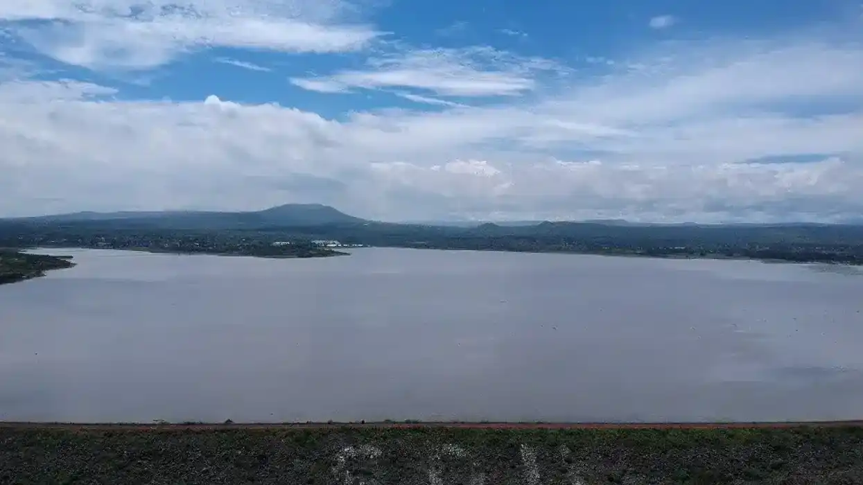 Vista aérea de una presa en Querétaro con almacenamiento de agua y cielo nublado.