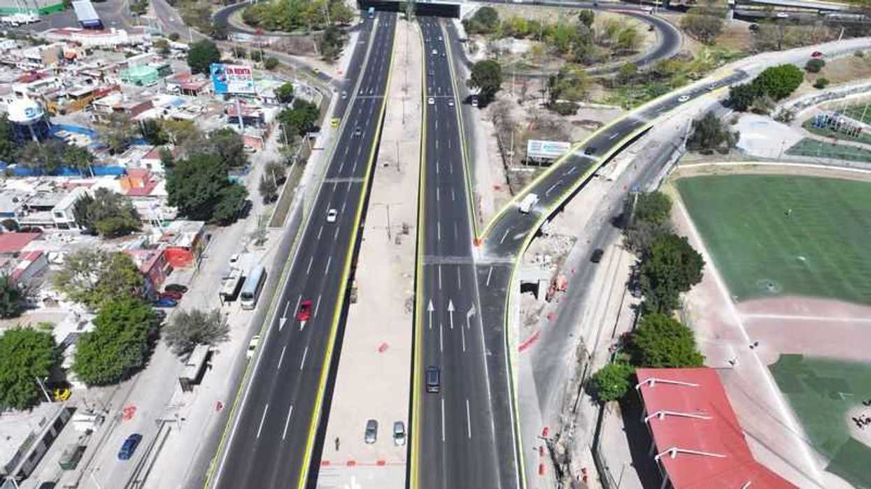 Vista aérea de una vialidad de Querétaro con carriles centrales, paso elevado y un campo de beisbol a un costado