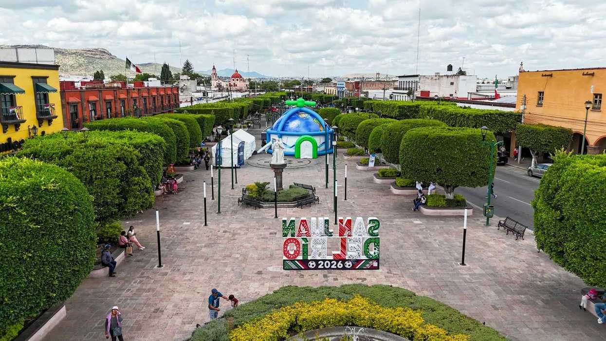Vista aérea del Cinedomo de la JAPAM, una estructura inflable en forma de globo terráqueo, junto al letrero San Juan del Río 2026 en una plaza del centro