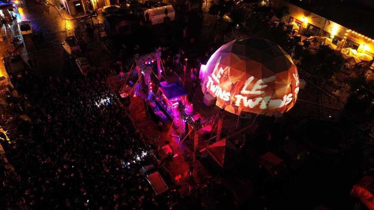 Vista aérea del domo inmersivo con el nombre Le Twins proyectado y el público de INVERSA 2026 en Plaza Fundadores