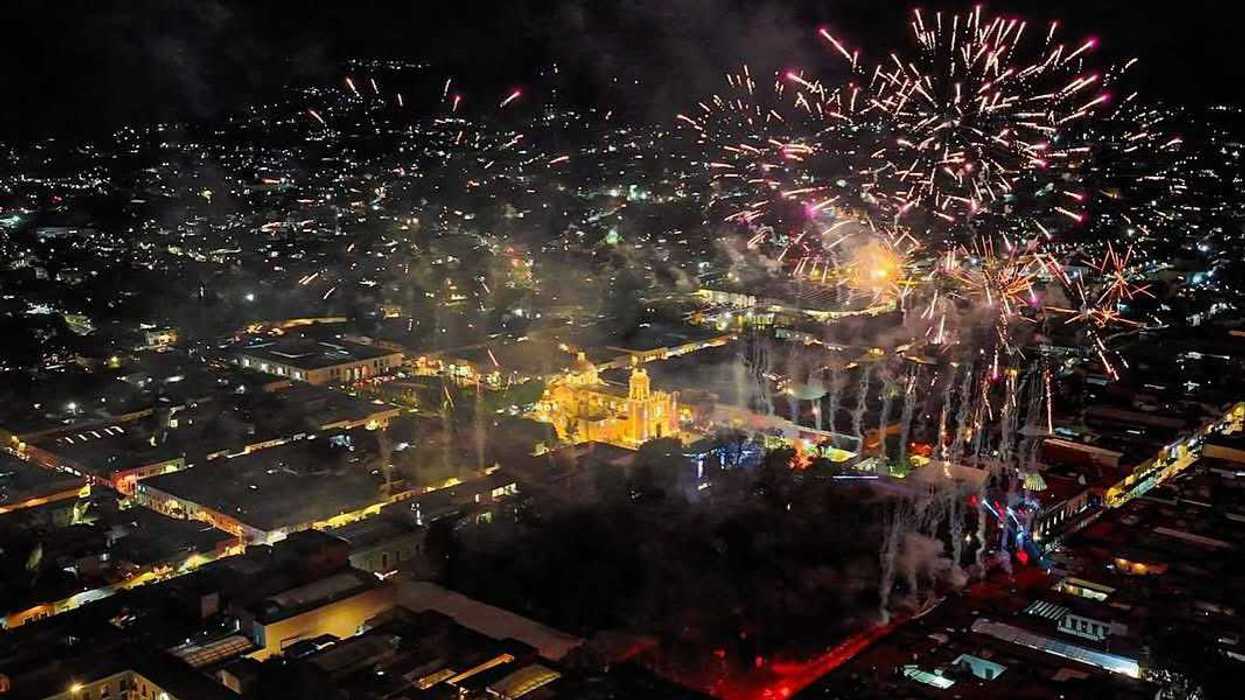 Vista aérea nocturna de la ciudad de Tlaxcala con fuegos artificiales sobre el centro iluminado durante el aniversario 501