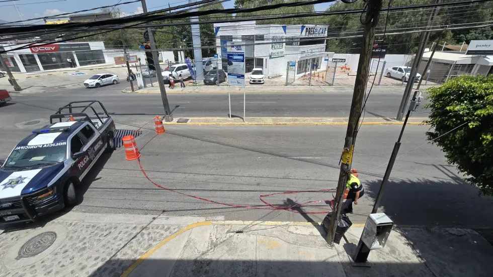 Vista de la intersecci\u00f3n de Boulevard Hidalgo con patrulla municipal y se\u00f1alizaci\u00f3n de peligro durante los trabajos de reparaci\u00f3n vial en San Juan del R\u00edo.