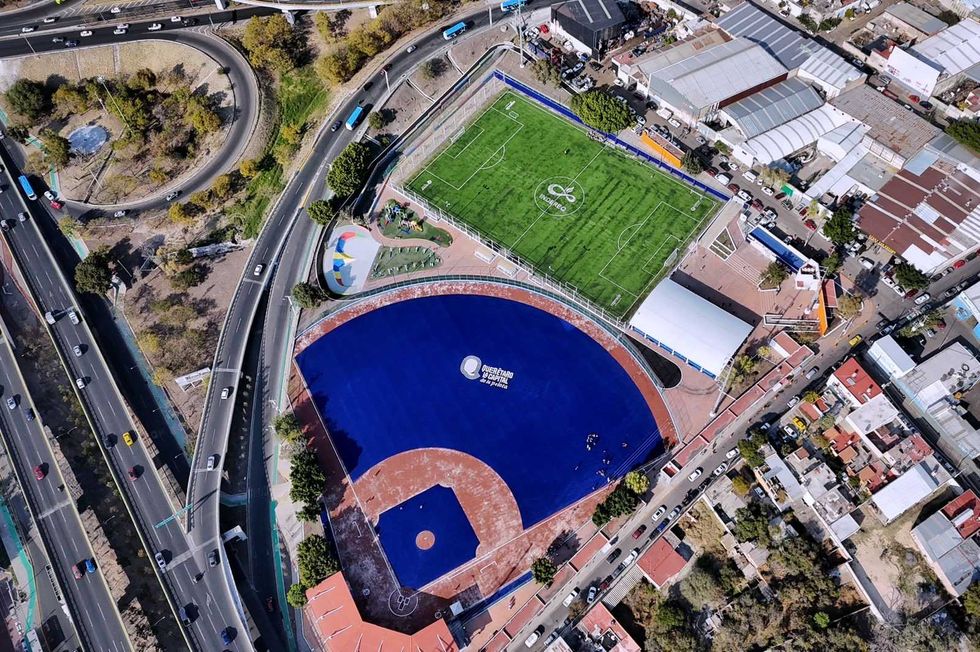 Vista de la Unidad Deportiva Ejido San Pablo rehabilitada con pasto sint\u00e9tico y gradas renovadas en Quer\u00e9taro