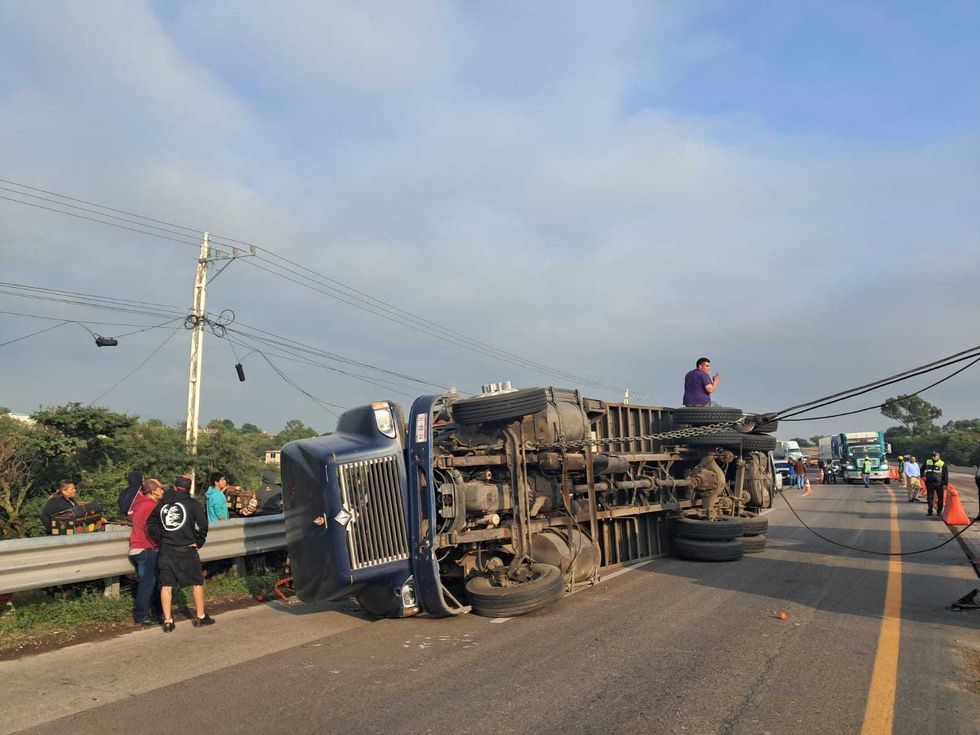 Vista del cami\u00f3n tipo Torton volcado sobre uno de sus costados en la autopista M\u00e9xico-Quer\u00e9taro.
