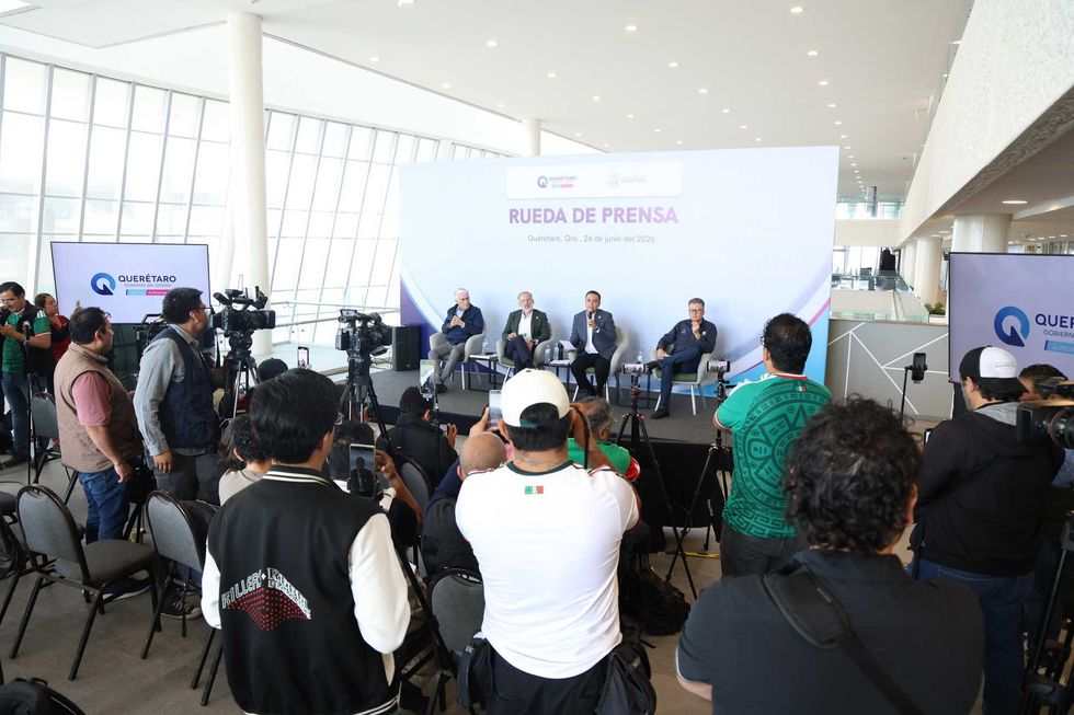 Vista general de la rueda de prensa del gobierno de Quer\u00e9taro sobre fallas el\u00e9ctricas, con funcionarios en el estrado y periodistas con c\u00e1maras en primer plano