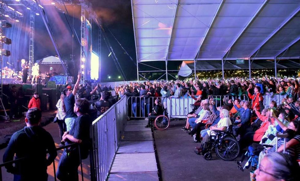 Vista general del escenario y del \u00e1rea reservada para asistentes en silla de ruedas durante un concierto.