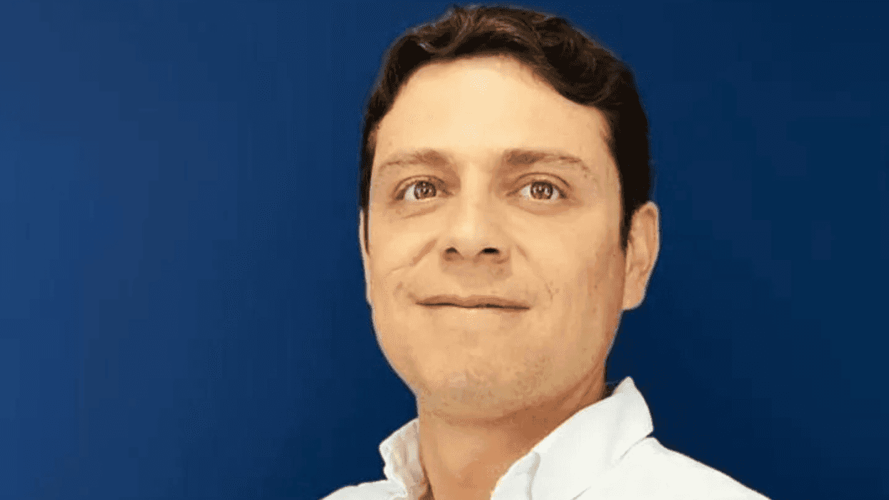 Yamil Olivier Ceja posa con camisa blanca frente a fondo azul