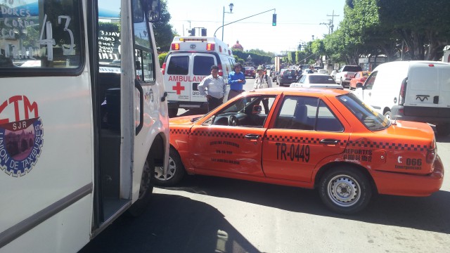 Camión de pasajeros arrastra a taxi.